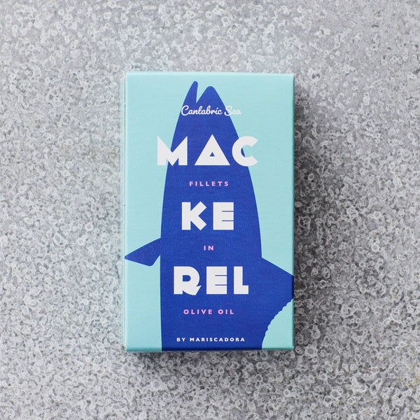 En rektangulær dåse med blå og blågrøn emballage mærket Skindfri makrelfilet i olivenolie by Don Gastronom, med en stiliseret fisk på en spættet grå overflade - en elegant tilføjelse til din superfoods-samling.