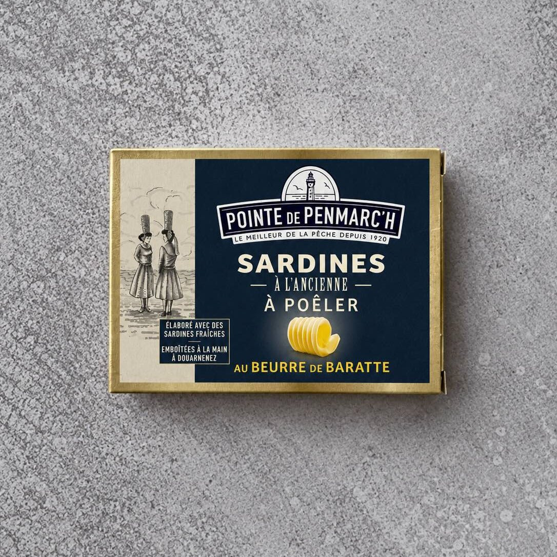 En rektangulær blikdåse med Pointe de Penmarc’h Sardiner med kærnet smør, der er prydet med en illustration af to kvinder, der bærer kurve på hovedet, samt et symbol på en smørkrølle.