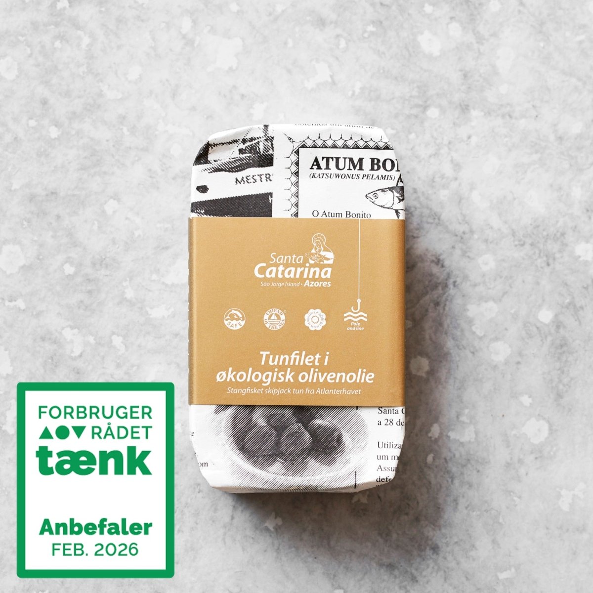 En rektangulær dåse Santa Catarina Tunfilet i økologisk olivenolie, indpakket i en avislignende emballage med en brun etiket og et grønt stempel, der certificerer den som Forbrugerrådet Tænk Bedst i test, FEB 2026.