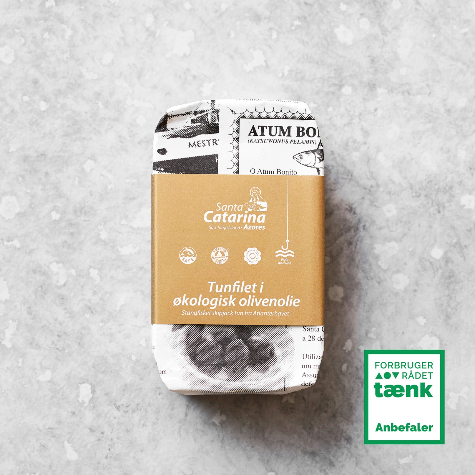 En dåse Santa Catarina Tunfilet i økologisk olivenolie med brun og hvid emballage står på en lysegrå stenoverflade. I nederste højre hjørne ses en grøn etiket fra Forbrugerrådet Tænk Anbefaler.