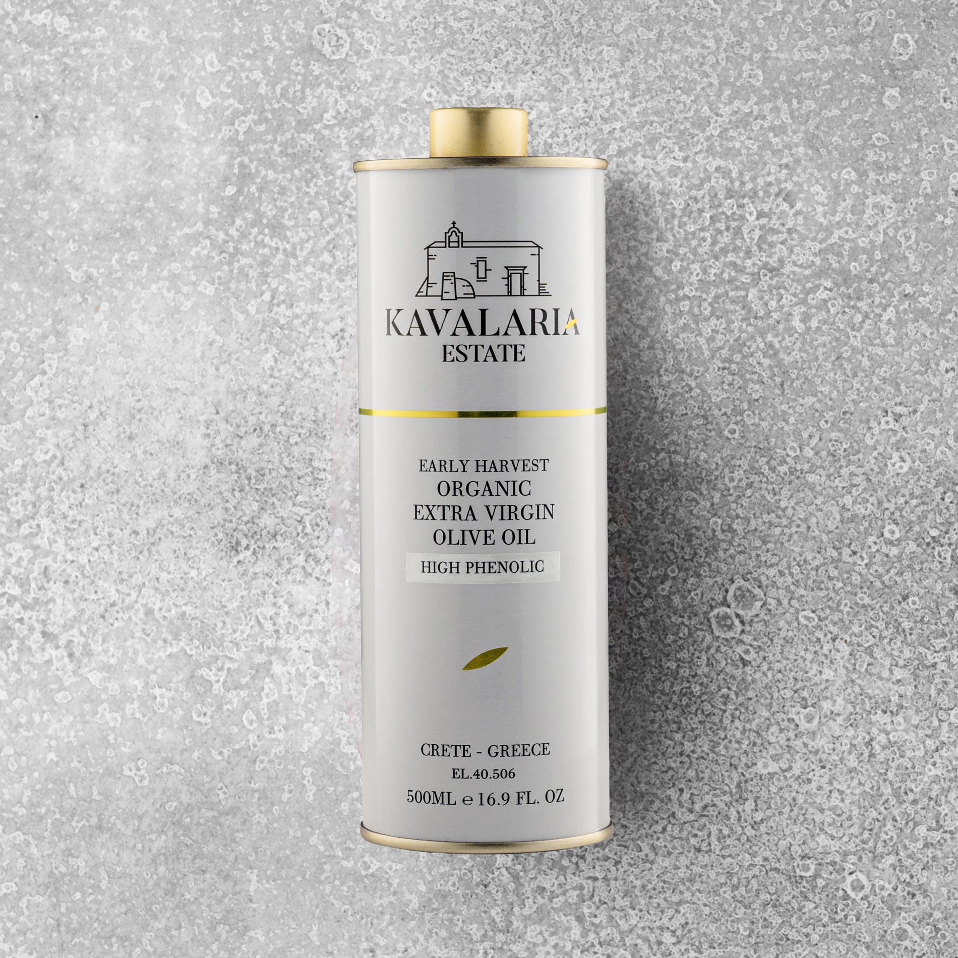 En 500 ml metalbeholder med KAVALARIA ESTATE Økologisk Ekstra Jomfru Olivenolie står oprejst på en struktureret grå overflade og er prydet med et minimalistisk logo i hvidt og guld samt en lille illustration af en bygning fra Kreta.