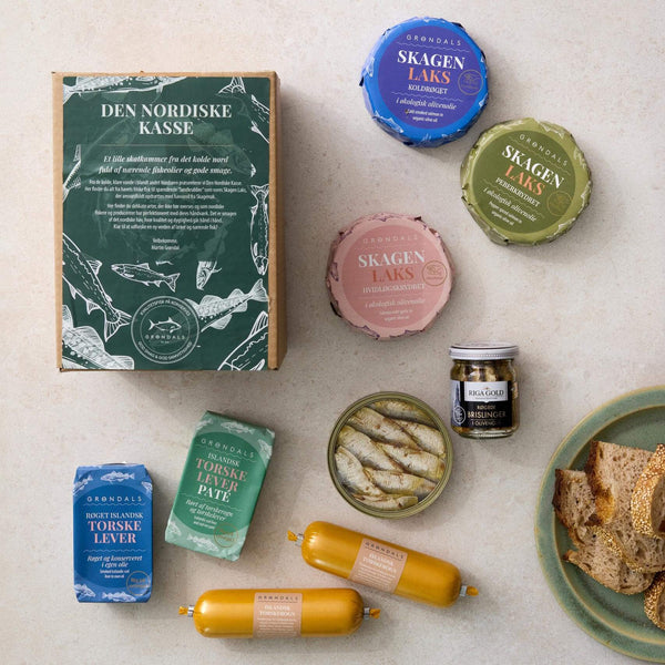 Grøndals Den Nordiske Kasse - en stor grøn kasse - indeholder nordisk fisk og skaldyr i dåser, glas og pølseformede pakker, alt sammen arrangeret på en lys flade med skiveskåret brød for at fremhæve smagen fra nordøstatlanten.