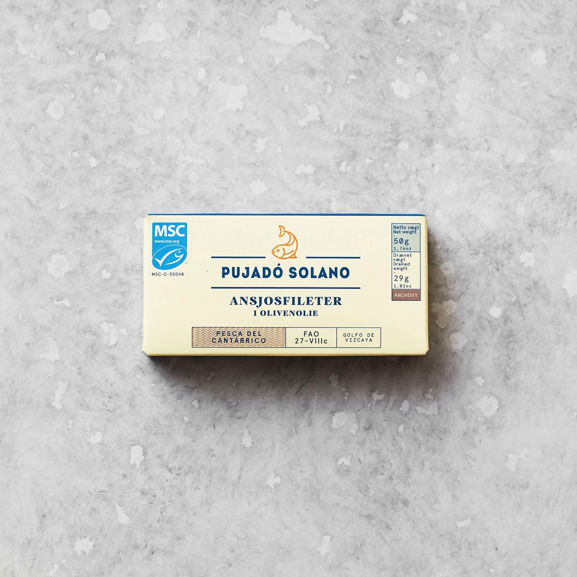 En dåse Pujadó Solano ansjosfileter i olivenolie placeret på en lysegrå baggrund. Dåsen er mærket med MSC-certificering og indeholder ansjosfileter fanget i Biscayabugten.
