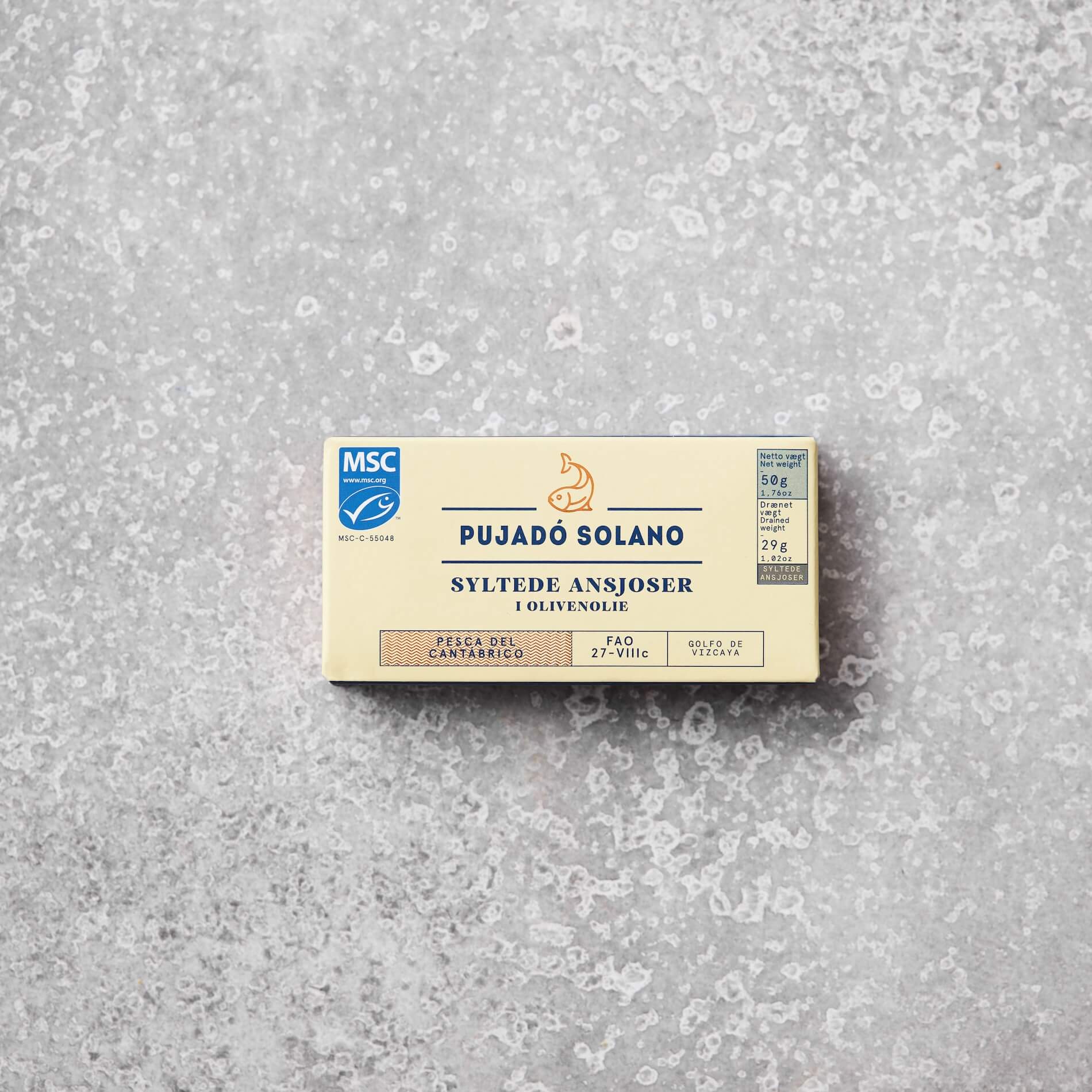 En pakke Pujadó Solano syltede ansjoser i olivenolie fra Grøndals, præsenteret på en lys grå baggrund. Pakken er MSC-certificeret og angiver produktets oprindelse fra Cantabrico-regionen.