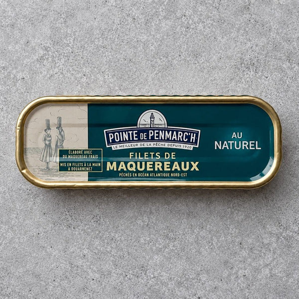 Rektangulær dåse med Pointe de Penmarc’h Makrelfileter i letsaltet vand med en blågrøn etiket, der viser en illustration af to kvinder, der bærer kurve, samt et fyrtårnsemblem.
