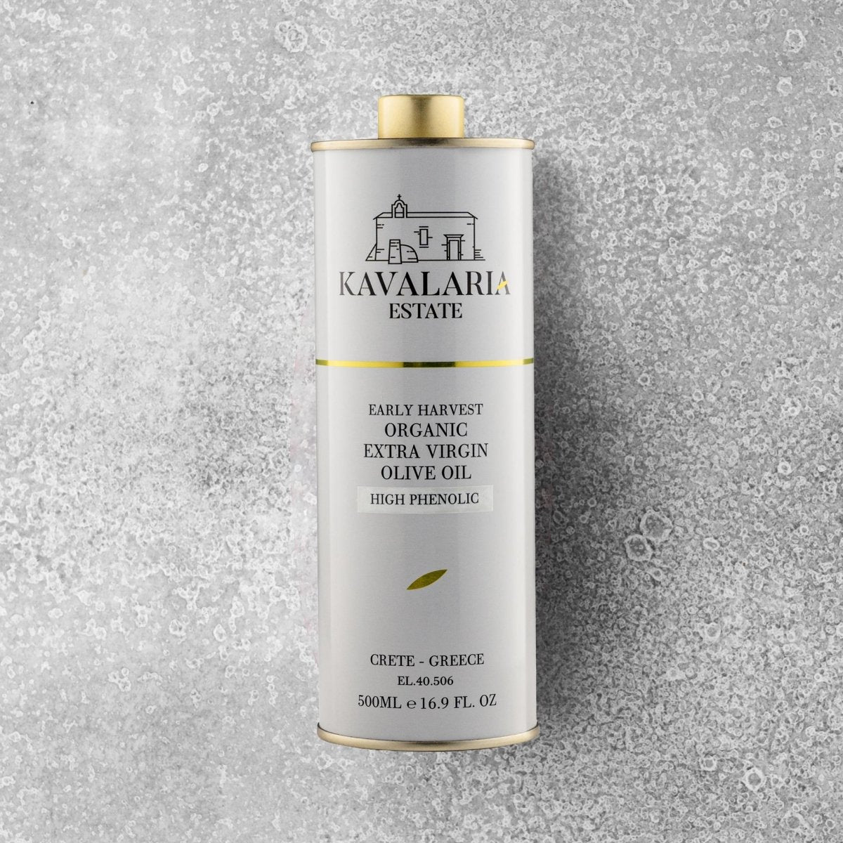 En 500 ml metalbeholder med KAVALARIA ESTATE Økologisk Ekstra Jomfru Olivenolie står oprejst på en struktureret grå overflade og er prydet med et minimalistisk logo i hvidt og guld samt en lille illustration af en bygning fra Kreta.