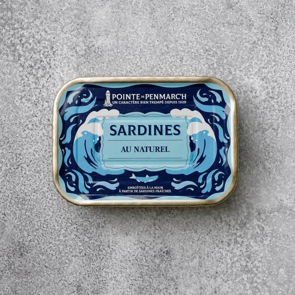 Rektangulær dåse med Pointe de Penmarc’h Sardiner i letsaltet vand med blå dekorative bølger og tekst på etiketten.