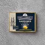 En rektangulær blikdåse med Pointe de Penmarc’h Sardiner med kærnet smør, der er prydet med en illustration af to kvinder, der bærer kurve på hovedet, samt et symbol på en smørkrølle.